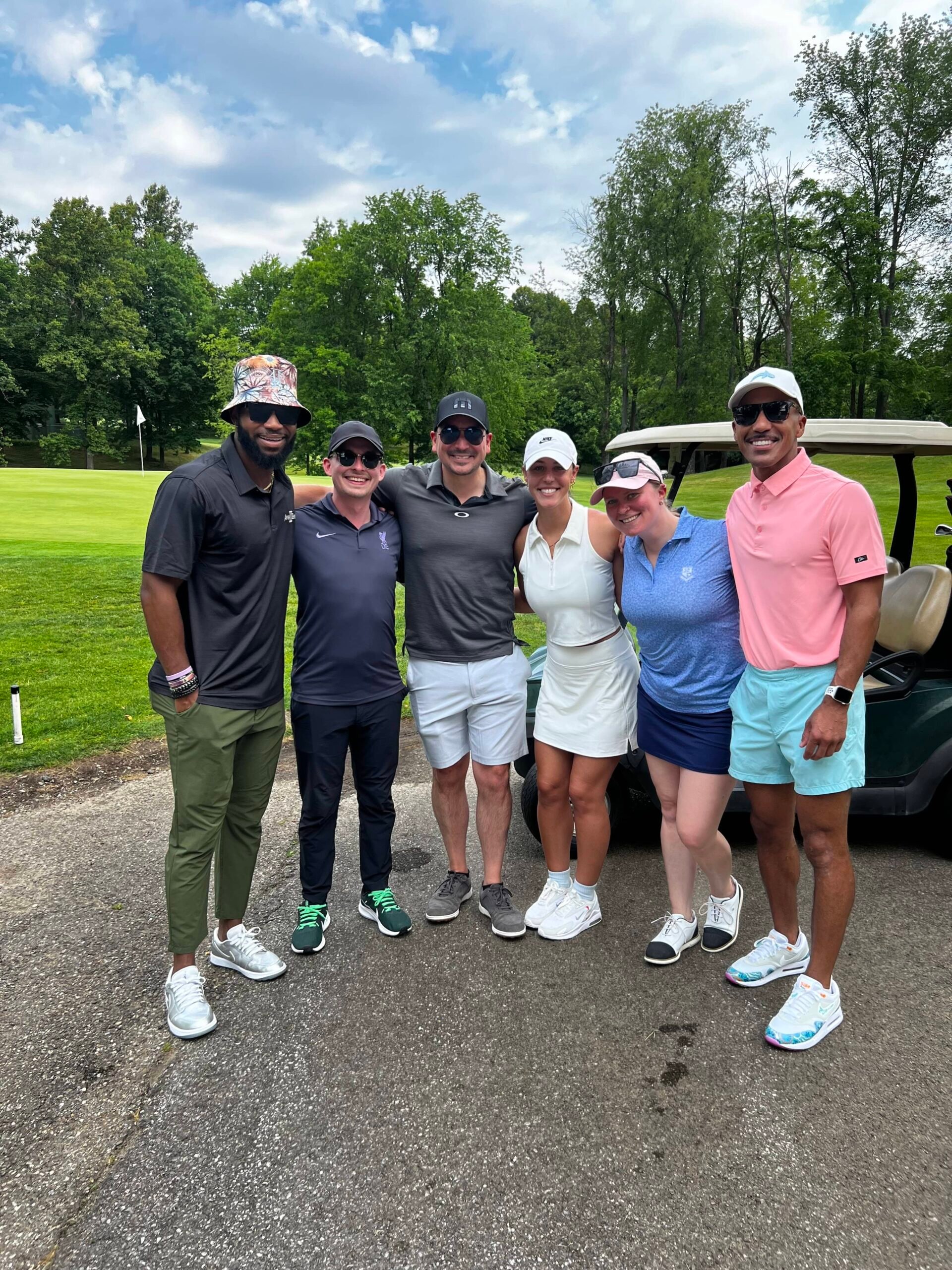 A group of people golfing pose for a picture together.