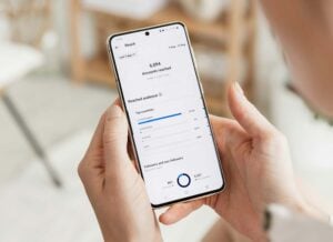 A person holds a phone displaying the audience reach of a post on social media.