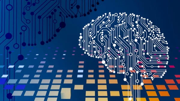 Abstract illustration of a brain formed by white circuit lines on a blue background with orange and gray grid blocks in the foreground.